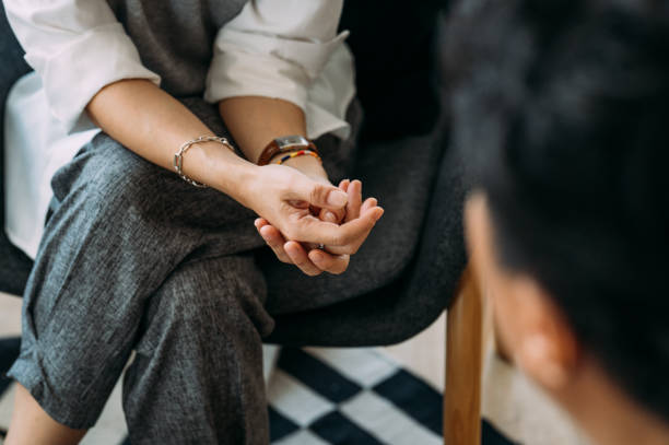 Person in therapy session, hands resting