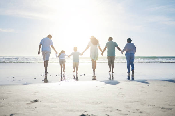 Family walking on beach holding hands